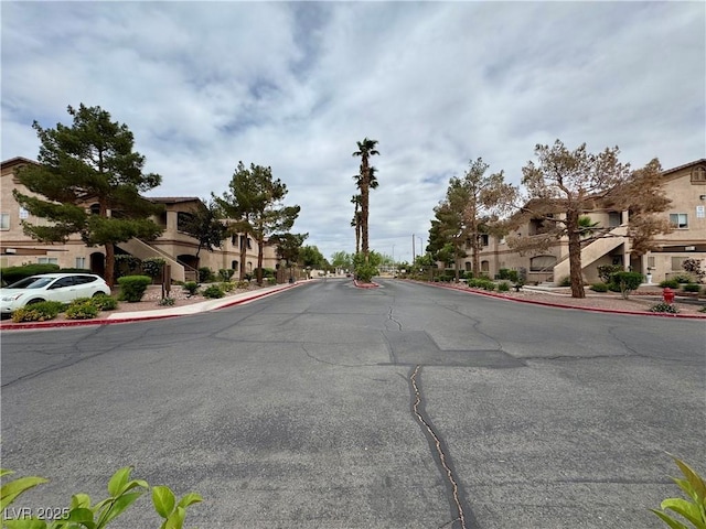 5751 Hacienda Ave Unit 135, Las Vegas, NV 89122 - view of asphalt road with curbs, a residential view, and sidewalks