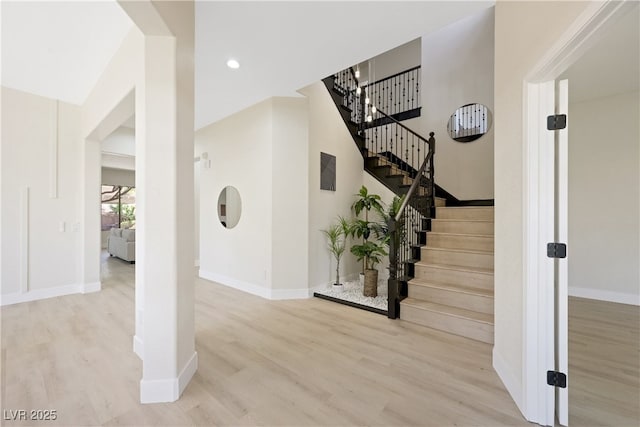 stairs with baseboards, recessed lighting, and wood finished floors