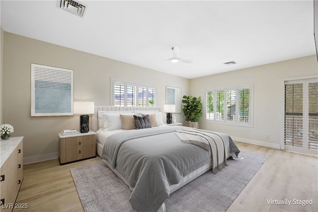 bedroom featuring light wood-type flooring, multiple windows, baseboards, and visible vents