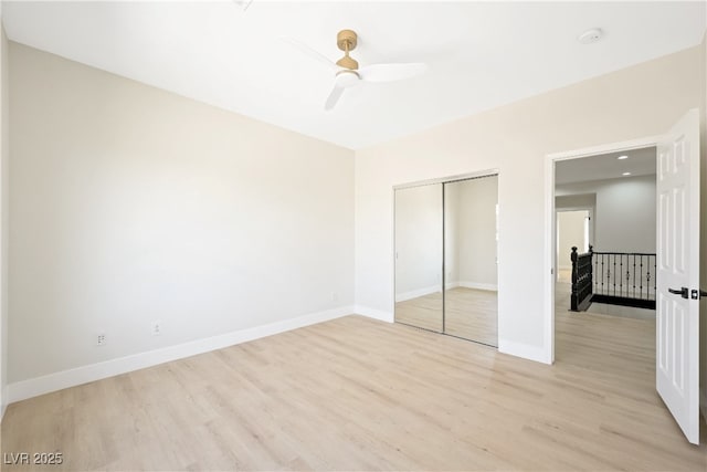 unfurnished bedroom with baseboards, light wood-style floors, and a closet