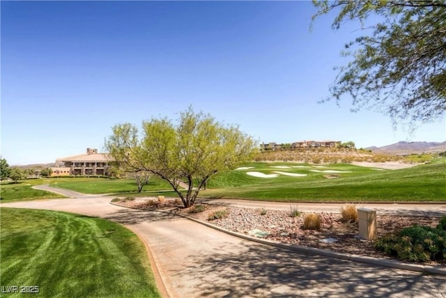 surrounding community featuring view of golf course, a mountain view, and a lawn