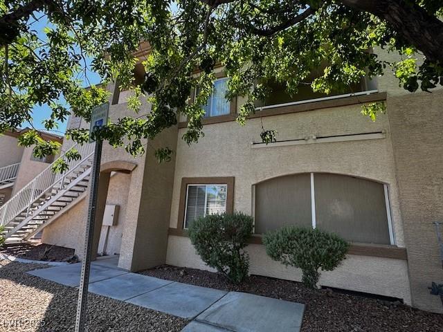 exterior space with stairway and stucco siding