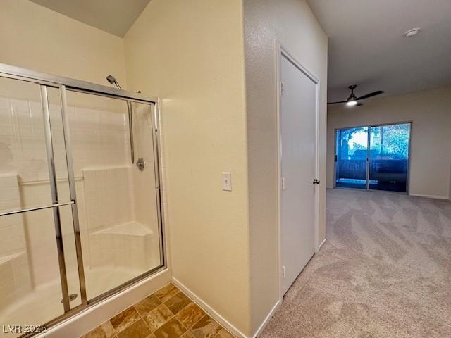 full bath with a shower stall, ceiling fan, and baseboards