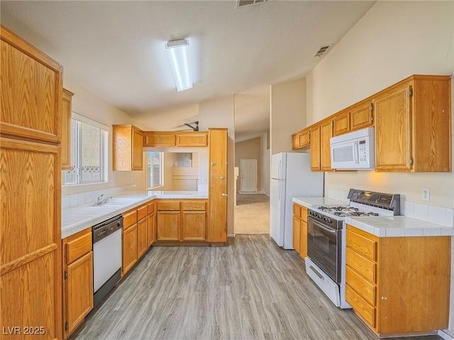 218 Pretty Sunset Ter, Henderson, NV 89015 - kitchen with a sink, light wood finished floors, tile counters, and white appliances