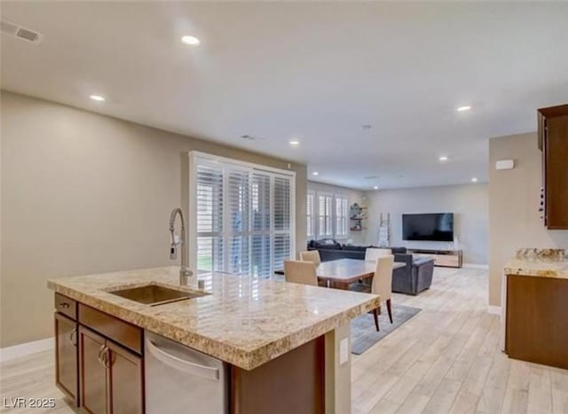 kitchen with visible vents, baseboards, a sink, light wood finished floors, and stainless steel dishwasher