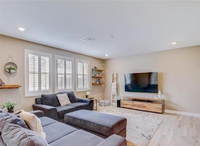 living room with wood finished floors, baseboards, visible vents, and recessed lighting
