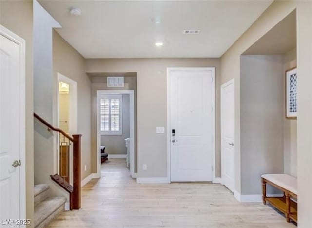 entryway featuring stairway, visible vents, and light wood-type flooring