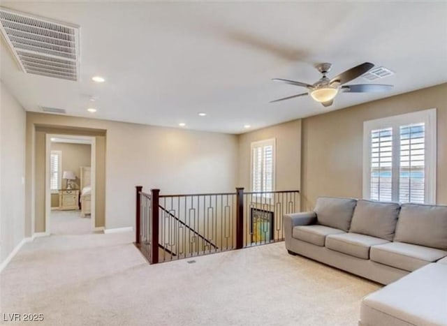 carpeted living area featuring baseboards, a ceiling fan, visible vents, and recessed lighting