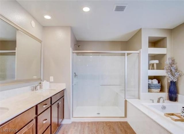 full bathroom with a garden tub, a shower stall, visible vents, a sink, and double vanity