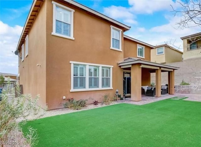 rear view of property with a patio and stucco siding