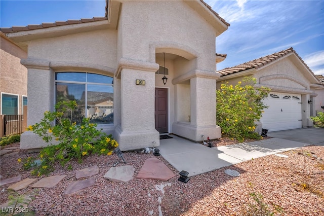90 Ancient Hills Ln, Henderson, NV 89074 - view of front facade featuring stucco siding, a tile roof, and an attached garage