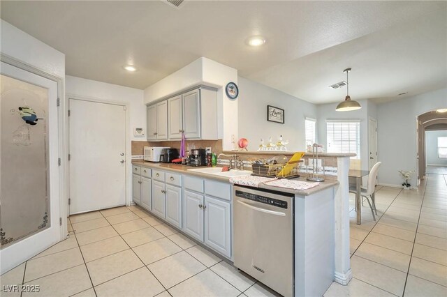 9383 Borough Park St, Las Vegas, NV 89178 - kitchen with light tile patterned floors, a peninsula, visible vents, dishwasher, and a sink