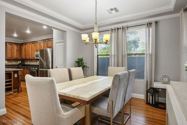 580 Via Di Parione Ct, Henderson, NV 89011 - dining room featuring baseboards, ornamental molding, visible vents, a chandelier, and hardwood / wood-style floors