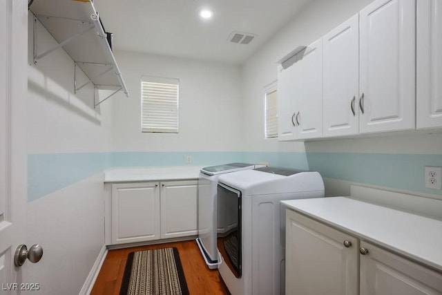 580 Via Di Parione Ct, Henderson, NV 89011 - clothes washing area featuring plenty of natural light, dark wood-style flooring, visible vents, separate washer and dryer, and cabinet space