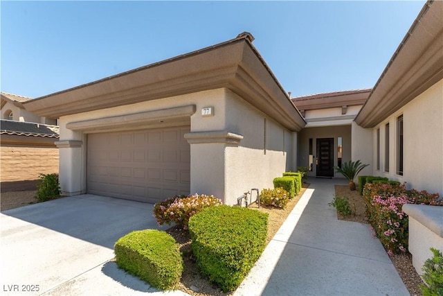 view of side of home featuring driveway, a garage, and stucco siding