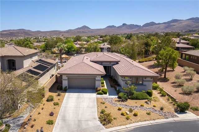 view of front of house featuring a mountain view, a garage, stucco siding, and concrete driveway