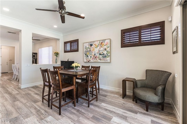 dining room featuring light wood-style flooring, ceiling fan, ornamental molding, and baseboards