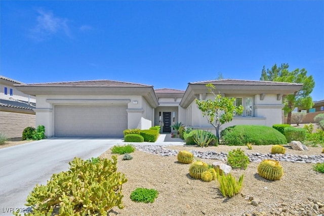 prairie-style house featuring driveway, stucco siding, and an attached garage