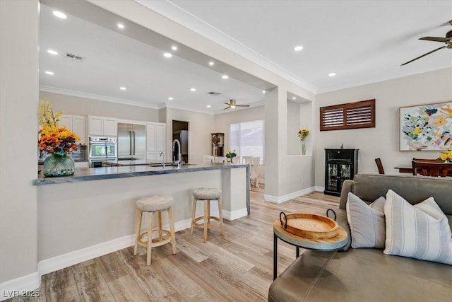 kitchen featuring crown molding, a ceiling fan, white cabinetry, and appliances with stainless steel finishes