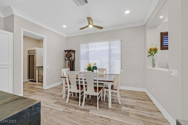 dining room with visible vents, ornamental molding, light wood finished floors, wine cooler, and a ceiling fan