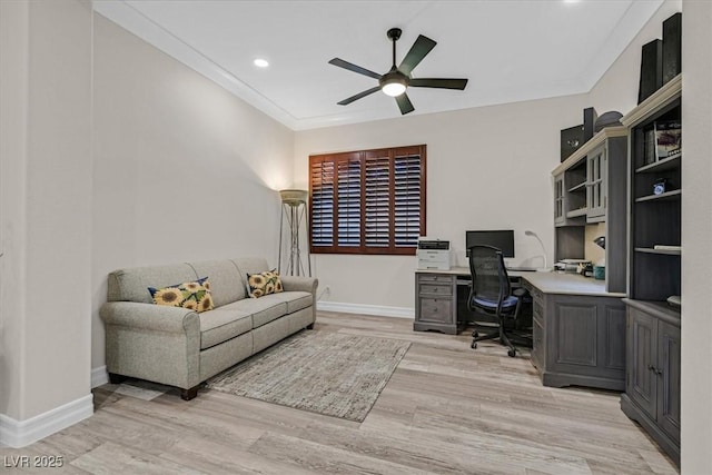 office with built in desk, light wood finished floors, baseboards, a ceiling fan, and crown molding