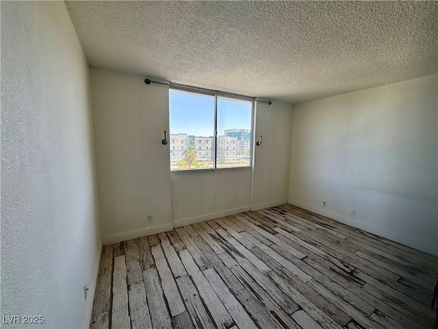 3930 University Center Dr Unit 409, Las Vegas, NV 89119 - unfurnished room with wood finished floors, a textured ceiling, and baseboards