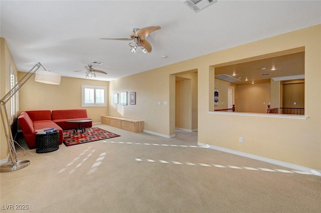 carpeted living area featuring ceiling fan, baseboards, and visible vents