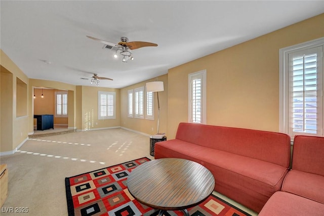 carpeted living room with visible vents, baseboards, and ceiling fan
