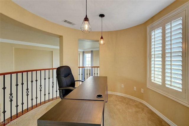 office space with carpet flooring, baseboards, and visible vents
