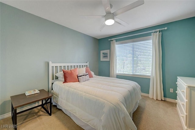 bedroom with light colored carpet, baseboards, and a ceiling fan