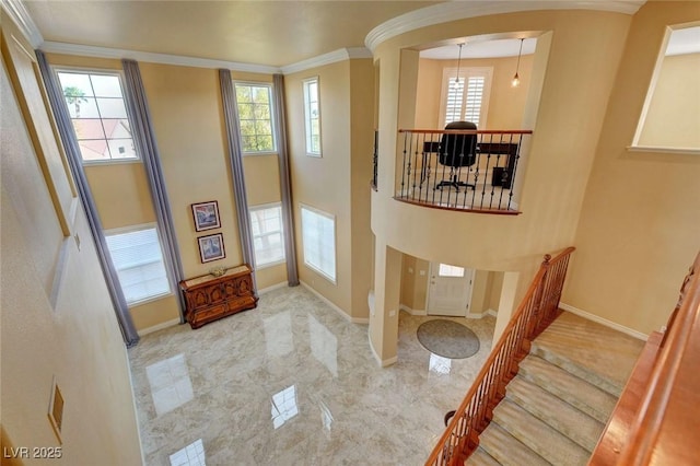 interior space featuring a wealth of natural light, arched walkways, and ornamental molding