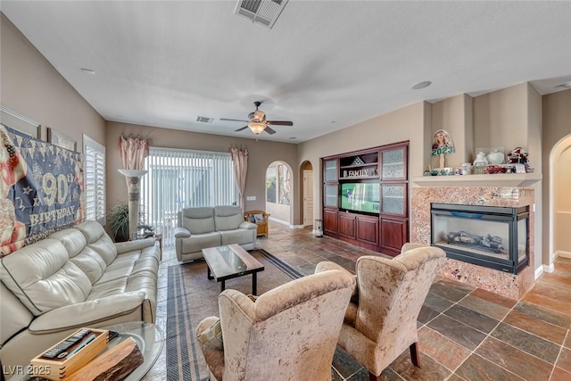 1045 Via Camelia St, Henderson, NV 89011 - living area with visible vents, baseboards, arched walkways, and stone tile floors