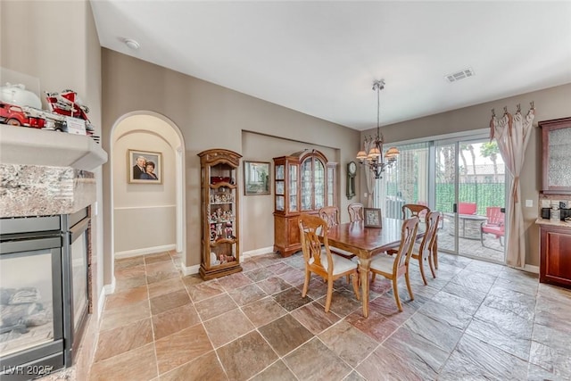 1045 Via Camelia St, Henderson, NV 89011 - dining area featuring a notable chandelier, visible vents, stone tile floors, and baseboards