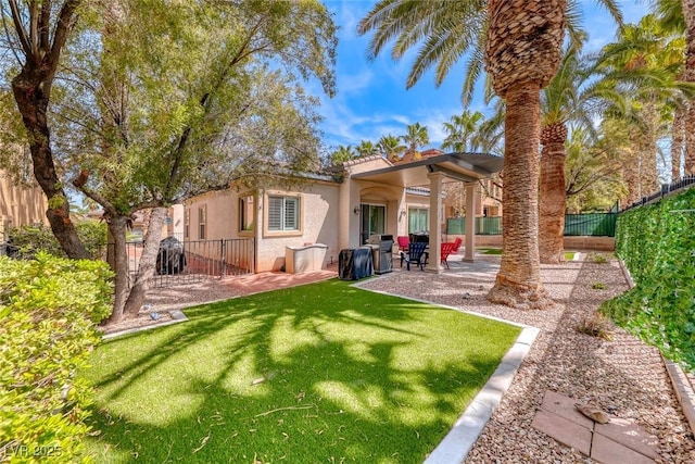 1045 Via Camelia St, Henderson, NV 89011 - back of property with stucco siding, a patio area, a fenced backyard, a yard, and a tiled roof