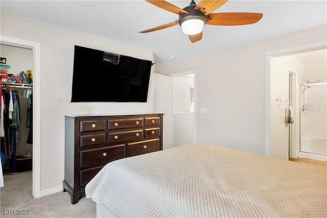 bedroom with a closet, baseboards, a spacious closet, a ceiling fan, and light colored carpet