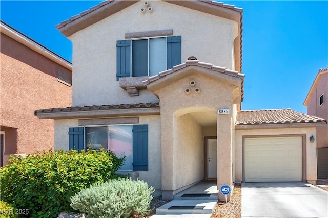 view of front of home with concrete driveway, stucco siding, and a tile roof