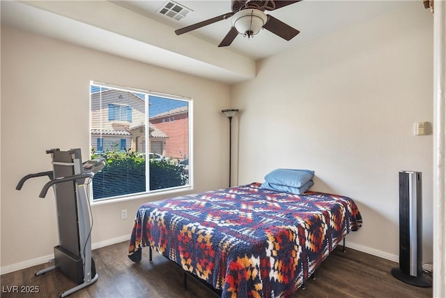 bedroom with ceiling fan, visible vents, baseboards, and wood finished floors