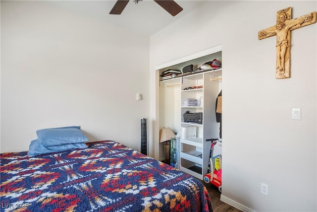 bedroom with a closet, baseboards, a ceiling fan, and wood finished floors