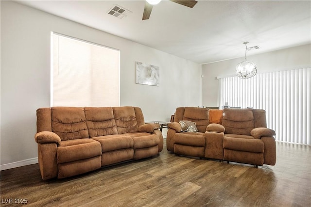 living room featuring visible vents, ceiling fan with notable chandelier, and wood finished floors