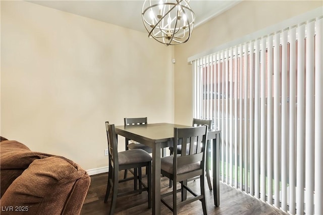 dining room with wood finished floors, an inviting chandelier, and baseboards