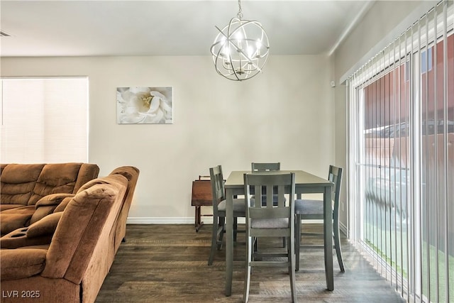 dining space featuring dark wood-type flooring, baseboards, and an inviting chandelier