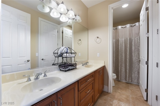 bathroom with a sink, tile patterned floors, toilet, and double vanity