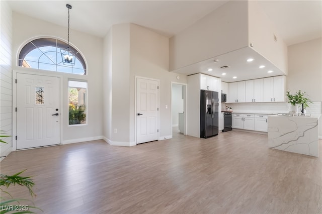 2725 Showcase Dr, Las Vegas, NV 89134 - entrance foyer featuring baseboards, a high ceiling, light wood-type flooring, a chandelier, and recessed lighting