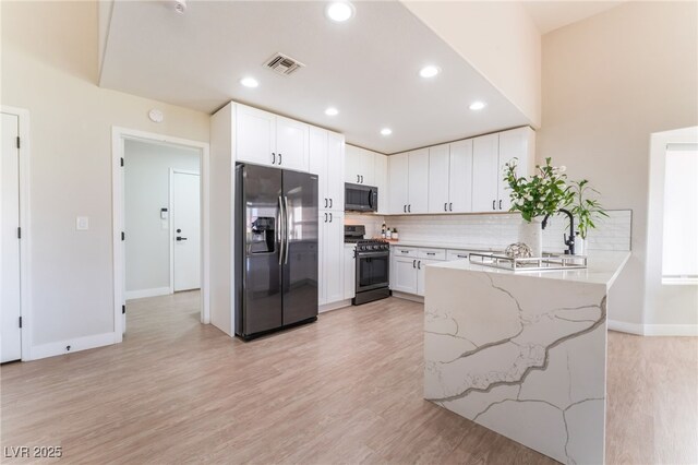 2725 Showcase Dr, Las Vegas, NV 89134 - kitchen with visible vents, fridge with ice dispenser, range with gas stovetop, light stone countertops, and backsplash