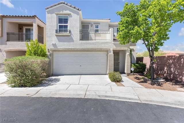 view of front of house featuring an attached garage, concrete driveway, stucco siding, and fence