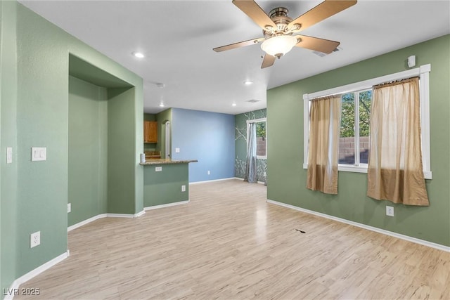 spare room featuring light wood-type flooring, baseboards, a ceiling fan, and recessed lighting
