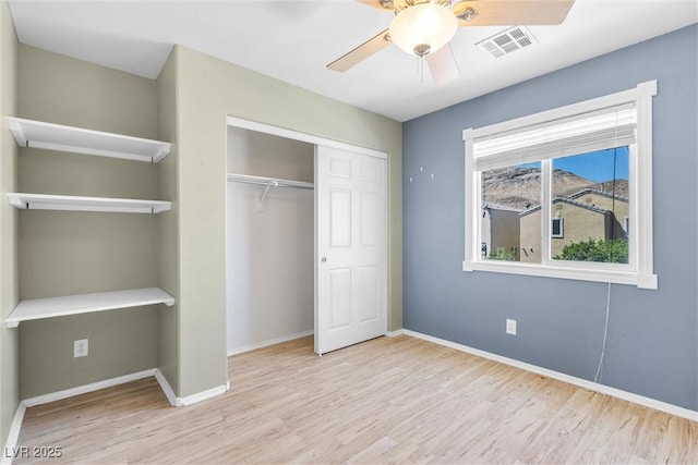 unfurnished bedroom with visible vents, baseboards, a closet, ceiling fan, and wood finished floors