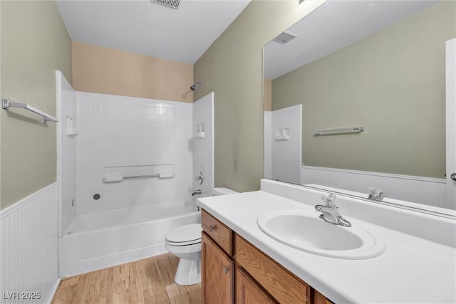 full bathroom with visible vents, toilet, shower / bathing tub combination, vanity, and wood finished floors