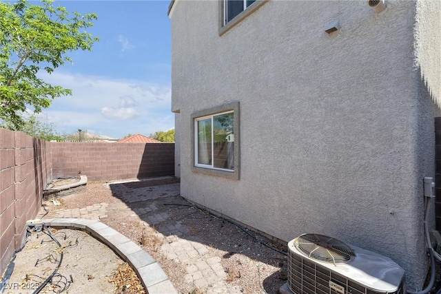 view of property exterior with a fenced backyard, stucco siding, and central AC