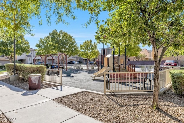 communal playground with a residential view and fence